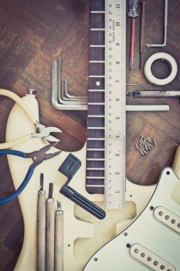 yellow electric guitar on wood in repair & luthier workshop, fixing & musical instrument repairing concept clipart