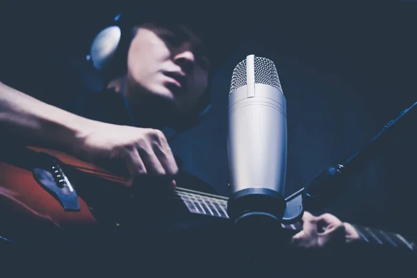 Asyalı erkek müzisyen Kondenser mikrofon kayıt stüdyosu olarak gitar çalmak — Stok fotoğraf