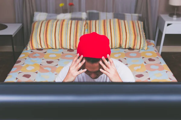 Maux de tête & déçu asiatique homme regarder la télévision dans chambre à coucher la nuit — Photo