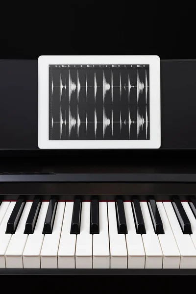 Teclas de piano com computador tablet, forma de onda digital na tela. tecnologia de produção musical — Fotografia de Stock