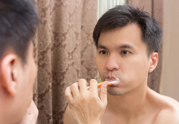 Miroir reflet de jeune asiatique beau homme brossant les dents — Photo