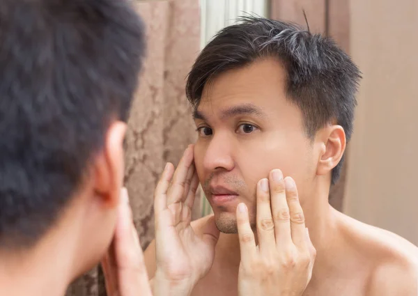 Miroir reflet d'un jeune asiatique bel homme regardant son visage — Photo