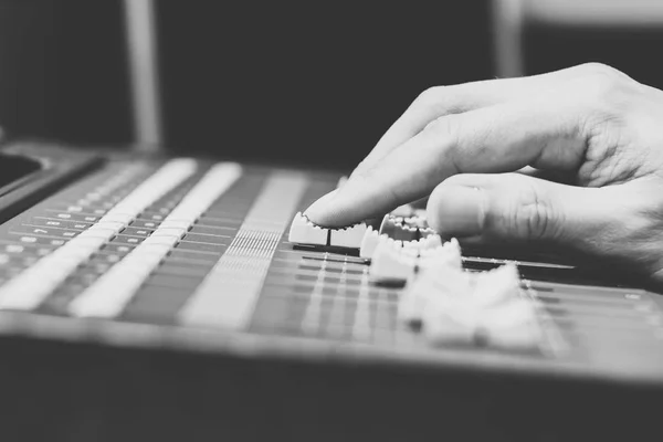 sound engineer hands working on sound mixer, black and white. shallow dept of field