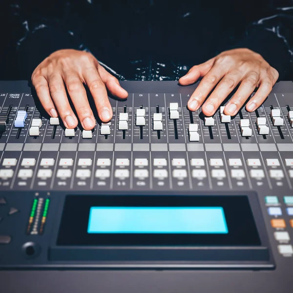 sound engineer hands working on sound mixer in digital music editing studio or live concert