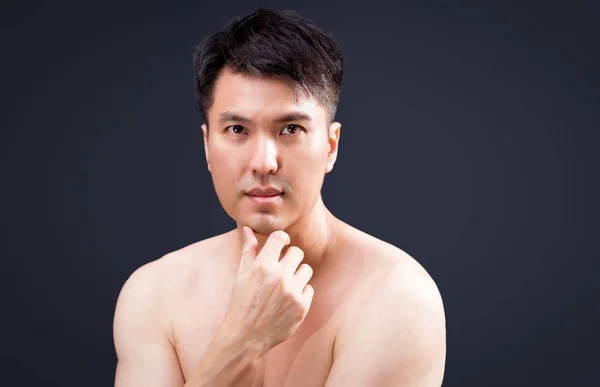 Retrato de asiático guapo joven sin camisa hombre mirando cámara mientras de pie sobre gris fondo, limpia y fresca piel — Foto de Stock