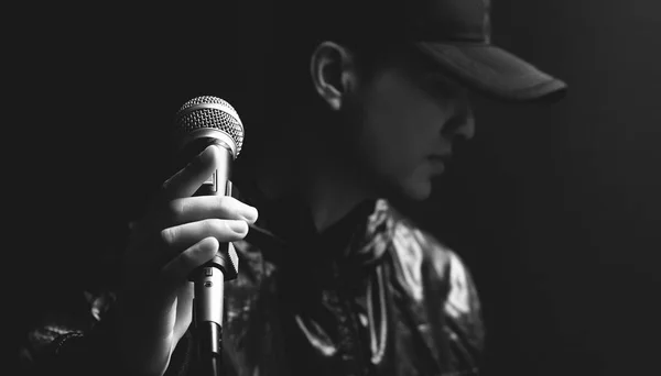Azjatycka piosenkarka męskie ręce na mikrofon — Zdjęcie stockowe