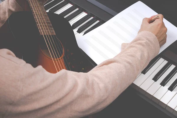 Compositor masculino escribiendo canción en hoja de música en blanco —  Fotos de Stock