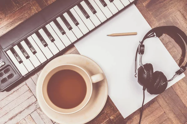 Concepto de compositor. piano, auriculares, taza de café, lápiz y papel blanco en blanco en el suelo de madera —  Fotos de Stock