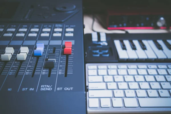 music production concept. sound mixer, midi keys, audio interface & computer keyboard