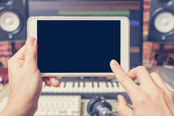 music background, fingers touching computer tablet in sound studio