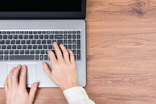 İnsanlar ve modern teknoloji kavramı. Erkek tipik dizüstü klavye üzerinde eller. Ofiste dizüstü bilgisayar üzerinde çalışan bir iş adamı. Erkek memur iletileri yazma