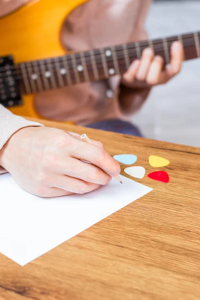 Compositor masculino mãos escrever música em branco papel branco com guitarra elétrica — Fotografia de Stock