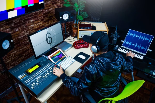 Asian male sound engineer working in digital audio & video editing post production studio Royalty Free Stock Photos