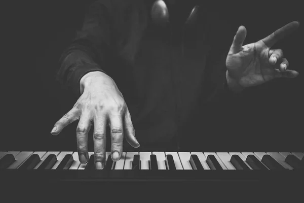 Musician hands playing on piano keys, black and white — Stock Photo, Image