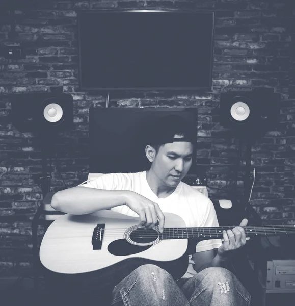Asiatico bel compositore suonare la chitarra acustica in studio di registrazione, in bianco e nero — Foto Stock