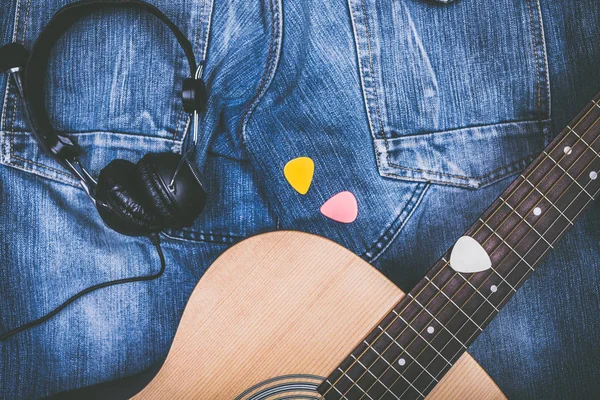 Акустична гітара, піки, навушники на блакитних джинсах — стокове фото