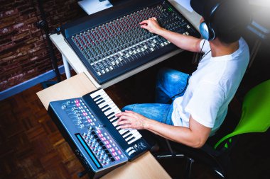 kayıt stüdyosunda MIDI klavye synthesizer oynarken erkek müzisyen
