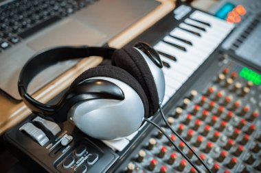 bilgisayar müzik, ev stüdyosu ekipman. dizüstü bilgisayar ve ses mikseri ile MIDI klavye synthesizer üzerinde kulaklık