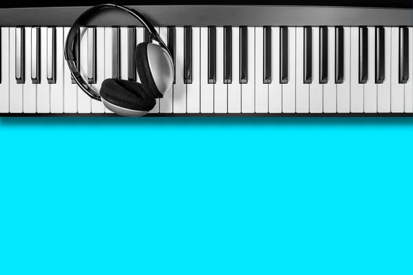 耳机在钢琴钥匙 隔绝在蓝色 音乐背景 — 图库照片