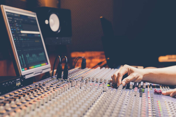 продюсер, звукорежиссер, руки звукоинженера, работающие на аудио микширующей консоли в радиовещании, студии звукозаписи
