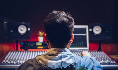 Kayıt stüdyosunda ses karıştırma konsolu üzerinde çalışan Asyalı erkek müzik yapımcısının arkası. müzik üretimi, yayıncılık, post prodüksiyon konsepti