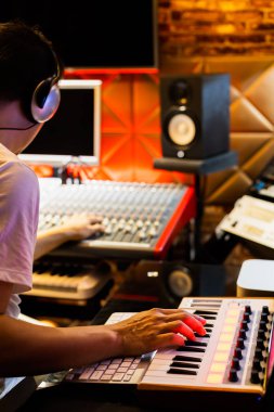 Erkek yapımcı, müzisyen, besteci ev kayıt stüdyosunda şarkı yapıyor. müzik üretim konsepti