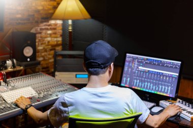 Asyalı profesyonel müzik yapımcısı, besteci, söz yazarı kayıt stüdyosunda çalışıyor.