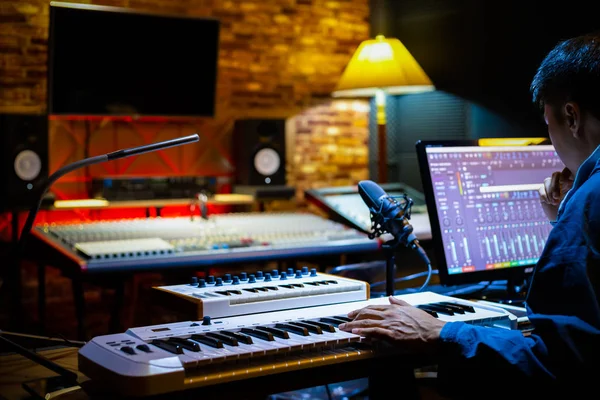 プロの男性音楽プロデューサーがレコーディングスタジオでコンピューター上で曲をアレンジ音楽制作のコンセプト — ストック写真