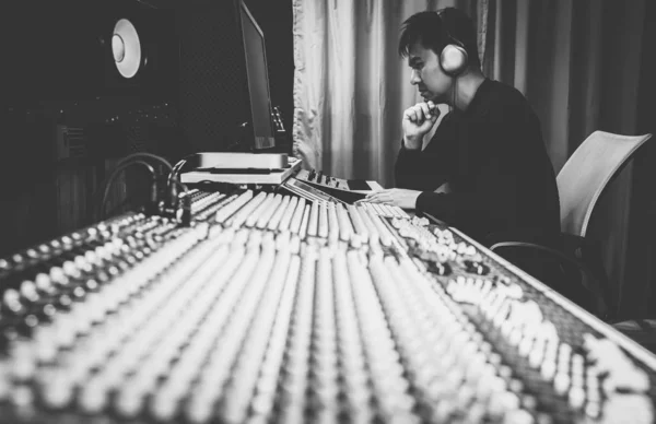 亚洲男性专业音乐制作人 音响工程师 作曲家 编曲人 在家庭录音室的音频混音控制台工作 黑人和白人 后期制作及广播概念 — 图库照片