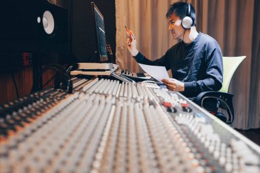 Asyalı genç profesyonel müzik yapımcısı, ses mühendisi, besteci, kayıt stüdyosunda çalışan aranjör. post prodüksiyon ve yayın kavramı