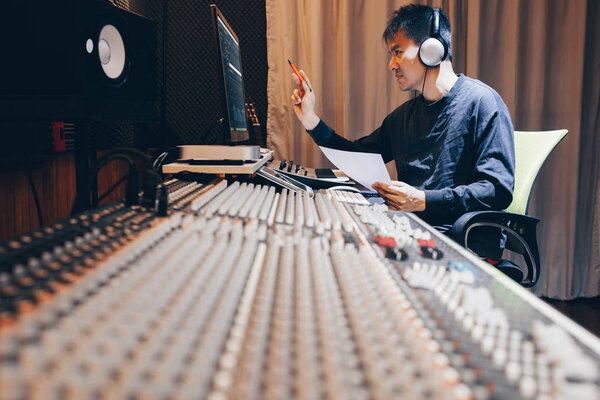 азиатский молодой мужчина профессиональный музыкальный продюсер, звукорежиссёр, композитор, аранжировщик, работающий в домашней студии звукозаписи. концепция постпродакшн и вещания
