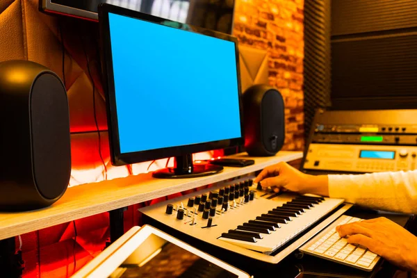 male music producer, composer arranging a song on computer in sound studio. music production technology concept