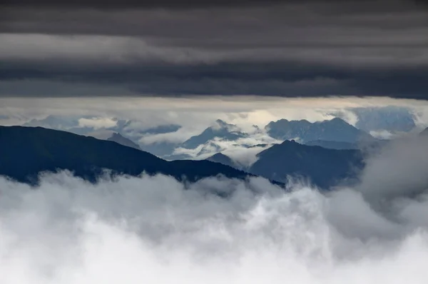 Nízko visící mraky obtáčejí hřebeny Karnské Alpy, Itálie — Stock fotografie