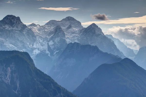 Zasněžený vrchol Triglav a mlhavé dolině Kot, Julské Alpy, Slovinsko — Stock fotografie