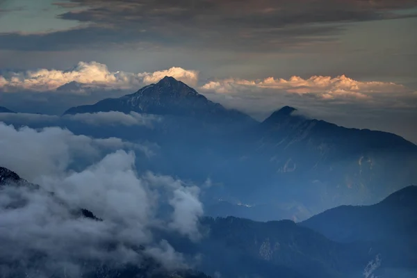 Temné hory, podzimní mlhy a sluncem zalité mraky ve Slovinské Alpy — Stock fotografie