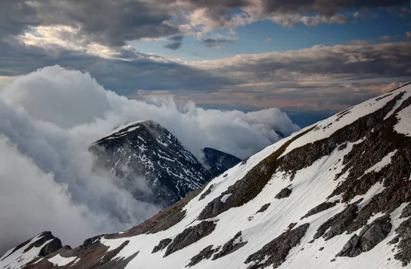 Καταρράκτης-σαν σύννεφα που ρέει κάτω από την απότομη κορυφογραμμή ιουλιανών — Φωτογραφία Αρχείου