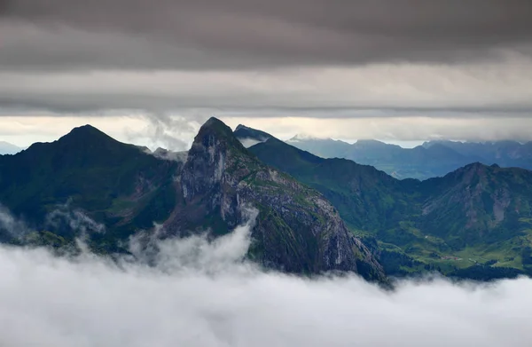 Picos afiados, vales verdes no nevoeiro e camadas de nuvens Alpes Cárnicos — Fotografia de Stock