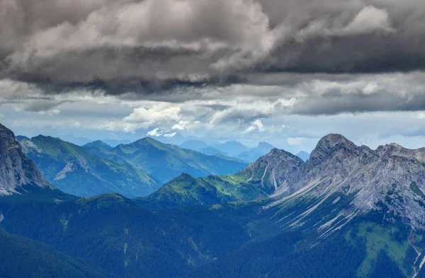 Lesy a vápencové vrcholy za temné mraky Karnské Alpy Itálie — Stock fotografie