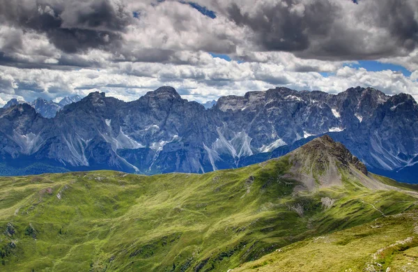 Alpes Cárnicos colinas verdes com parede de pedra calcária de Dolomitas Sextas — Fotografia de Stock
