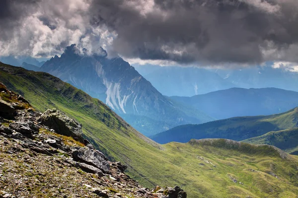 Bergrücken und Wiesen in blauem Nebel und grauen Wolken Karnien Italien — Stockfoto