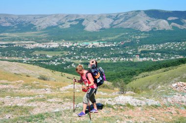 Perevalnoye, Kırım'da, Temmuz, 15, 2016. Kadın Doğu kayalıkları, alt Yaylası Chatyr-Dag Crimea'da boyunca düz arazi üzerinde bir sırt çantası ile gelir
