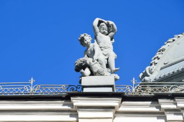 Moscow, Russia, April, 15, 2017. Fragment of the sculptural composition of putti frolicking babies on the roof of the main building of the complex of Sandunovsky baths at Neglinnaya, 14 clipart