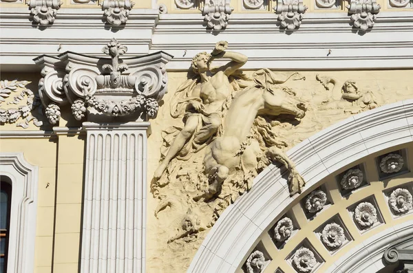 Moskva, Ryssland, April 15, 2017. Skulpturen på fasaden av den huvudsakliga byggnaden av Sandunovsky bad i Neglinnaya street. En man på hästryggen blåser jakthorn — Stockfoto