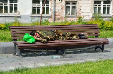 Moskova, Rusya, 12 Haziran 2017, evsiz bir adam Khitrovskaya meydanında bir bankta Moskova'da yaz aylarında uyku