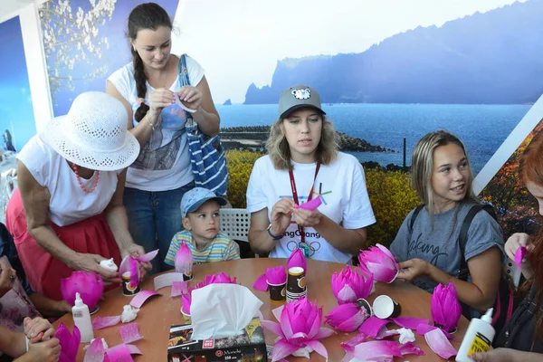 Vladivostok, Russia, September, 10, 2017. People taking part in master class "How to make a Lotus flower from the paper" on the promenade of  Far Eastern Federal University on island Russian — Stock Photo, Image