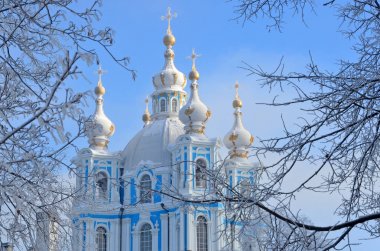 Russia, Saint-Petersburg. Smolny Cathedral in winter day. It's snowing, snowflakes in the sky clipart