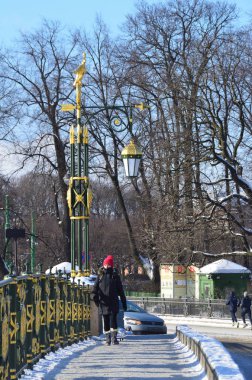 St Petersburg, Rusya, Şubat, 27, 2018. Kırmızı şapkalı kadın Panteleimonovsky köprüde kışın St. Petersburg'da gider