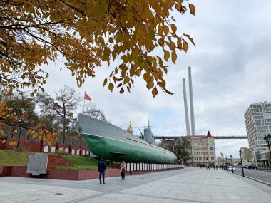 Vladivostok, Russia, October, 26, 2019. People walking near Guards red banner submarine S-56 (Stalinets) in the Memorial complex on Karabelnaya embankment in Vladivostok in cloudy autumn day