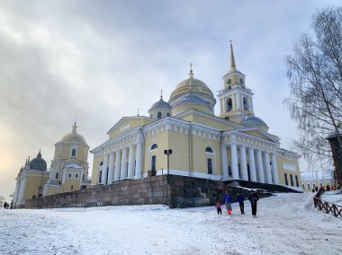 Ostashkov, Rusya, Ocak, 07, 2020. Bulutlu bir günde Nilo-Stolobenskaya 'da (Nilova) Epiphany Katedrali yakınlarında yürüyen insanlar görülüyor.