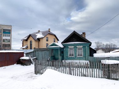 Kyshtym şehrindeki Sverdlov caddesindeki zengin taştan bir evin arka planındaki zavallı ahşap ev. Rusya, Chelyabinsk bölgesi